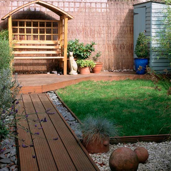 Small garden with decked path and wooden arbour