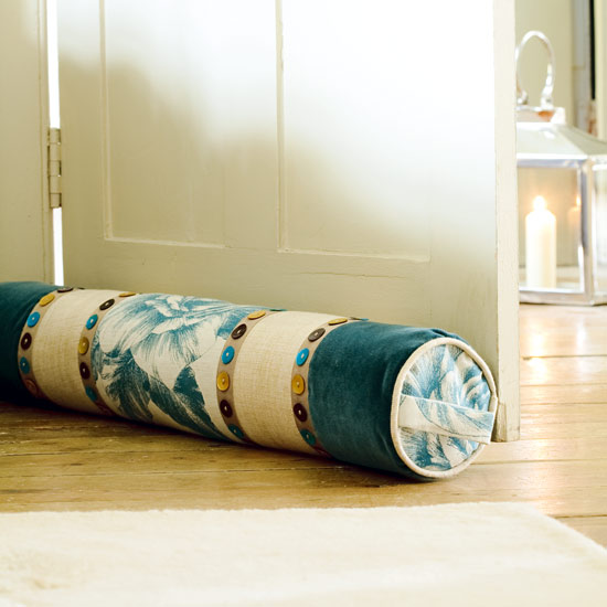 Join panels of linen and velvet and add button braid to make a sumptuous draught excluder or bolster cushion