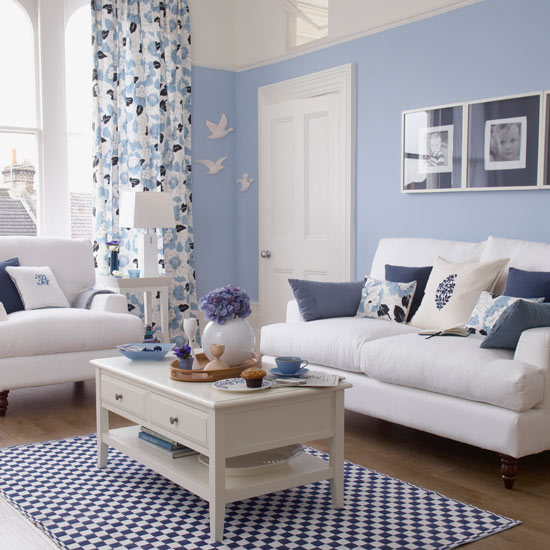Add definition to a light blue living room with accents in a darker shade