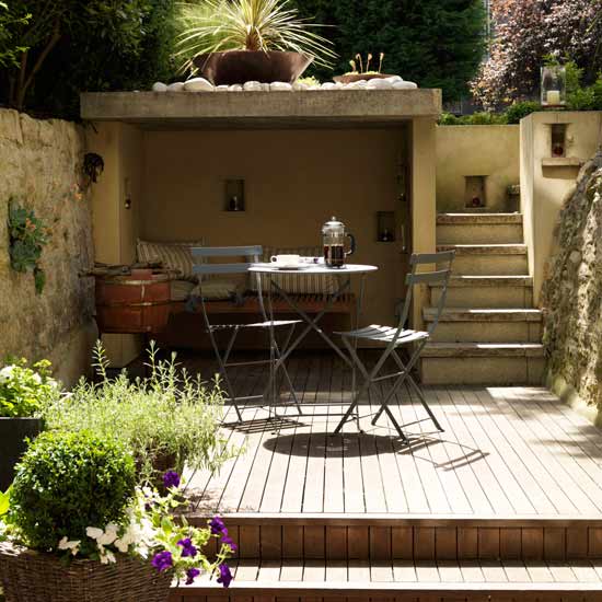 Small garden with decking, wooden table and chairs