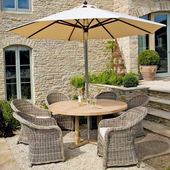 Turnberry South American oak table, £905; Antibes parasol, £300; Pesaro wicker chairs, £220 each, 
all Neptune.
