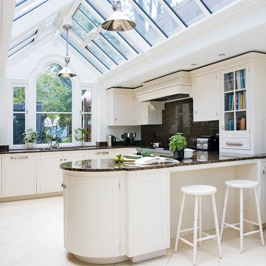 Kitchen extension with white kitchen island, white cabinetry and black 