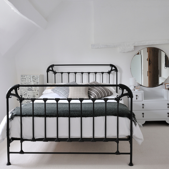 White country bedroom with black iron bed