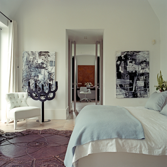 White and pastel blue bedroom with artwork