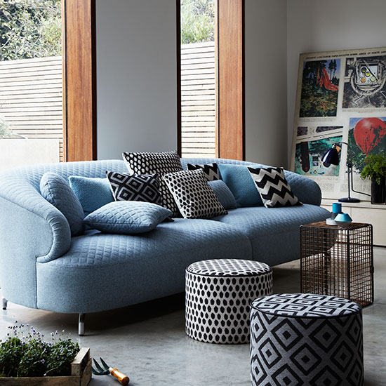 Modern living room with blue sofa and poufs