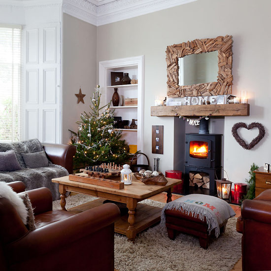 Country Christmas living room with neutral walls, wood flooring, neutral shag pile rug, wood coffee table, leather sofas, wood mirror frame and Christmas tree