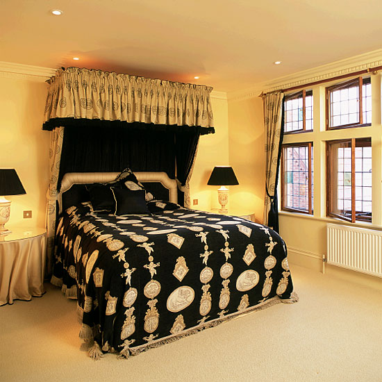 Yellow bedroom with black patterned canopied bed ...